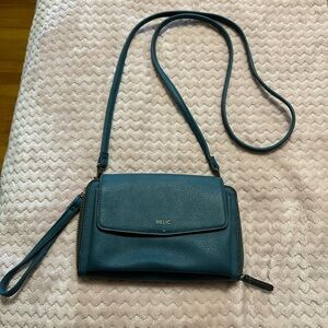 Teal bag, could be a crossbody or over the shoulder.